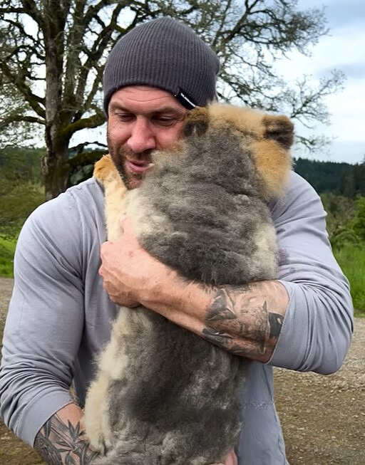 guy with cap holding a dog